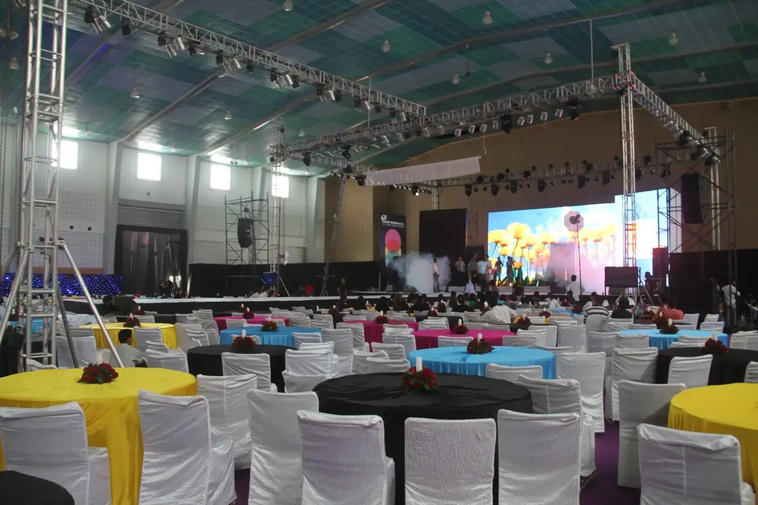 Man and woman speaking on stage at night with blue lighting